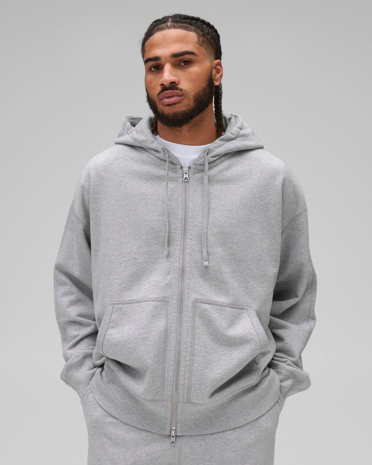 Grey Midweight Terry Relaxed Zip Hoodie with a full zipper, drawstrings, and front pockets, worn by a male model.