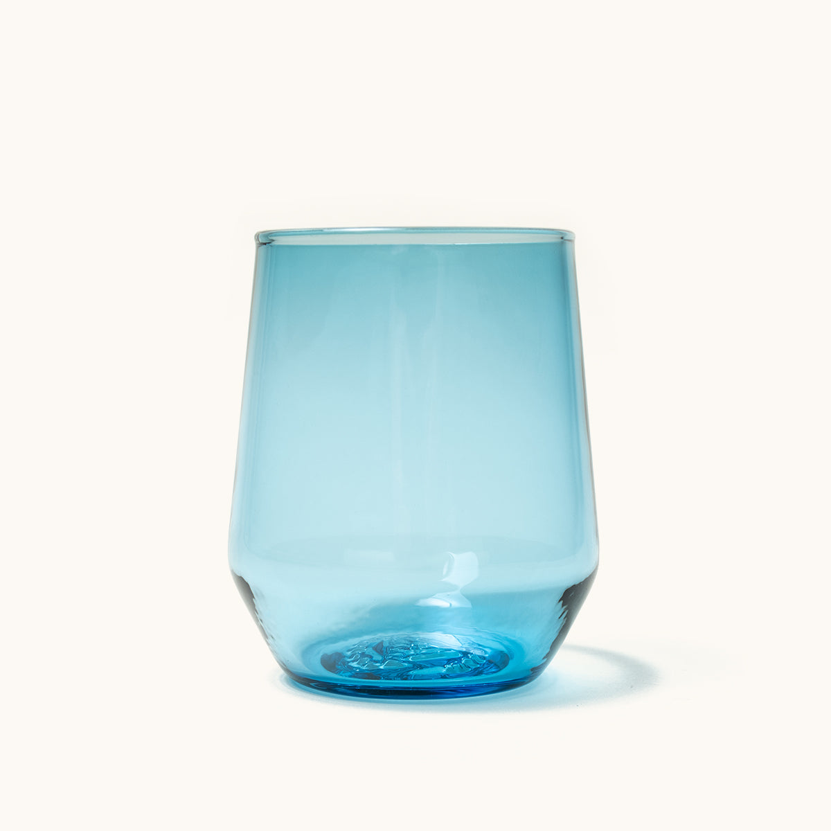 Translucent blue stemless wine glass with a tapered shape and thick base.