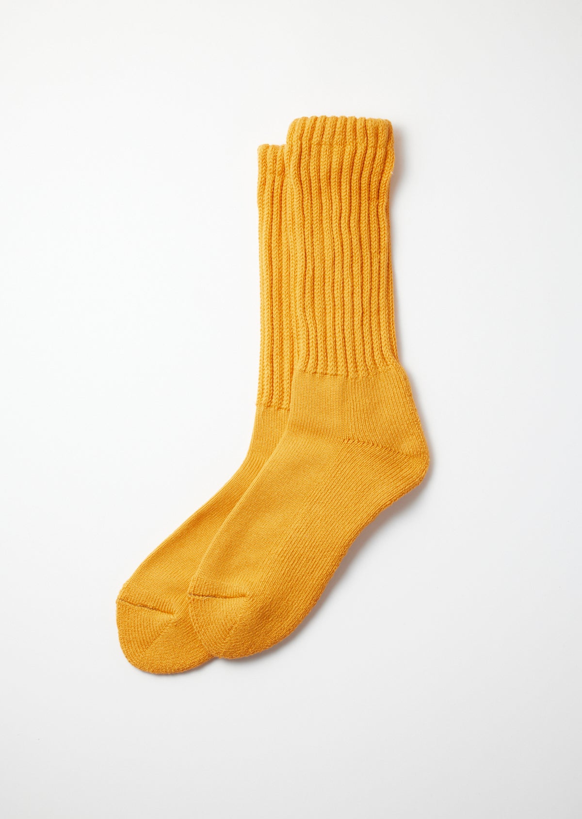 Mustard yellow loose pile crew socks with a ribbed knit texture, laid flat on a white background.
