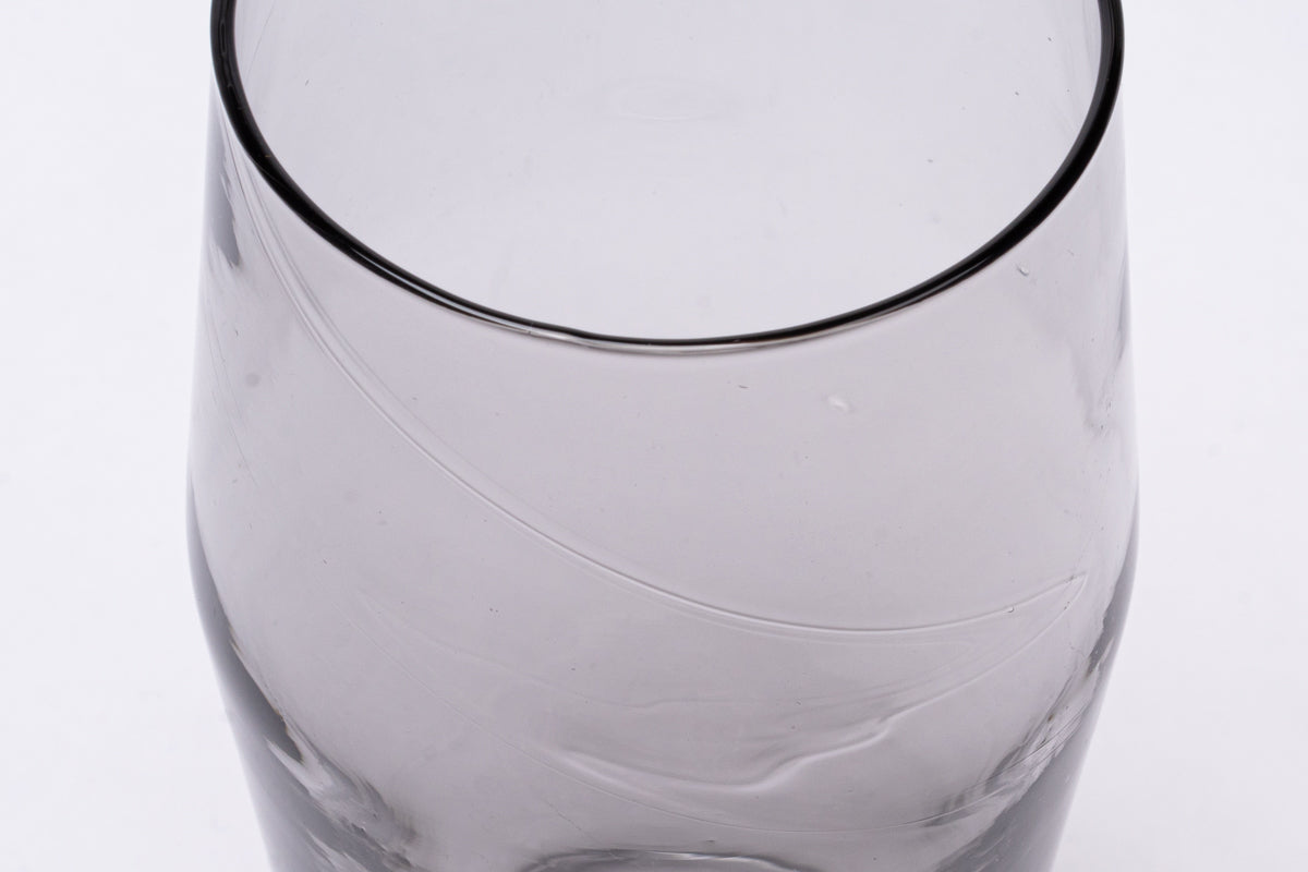 Cropped grey translucent B grade pint glass with a dark rim and subtle swirling marks.
