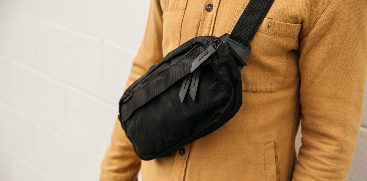 Minimal black crossbody bag on tan shirt, urban essentials for daily adventures.