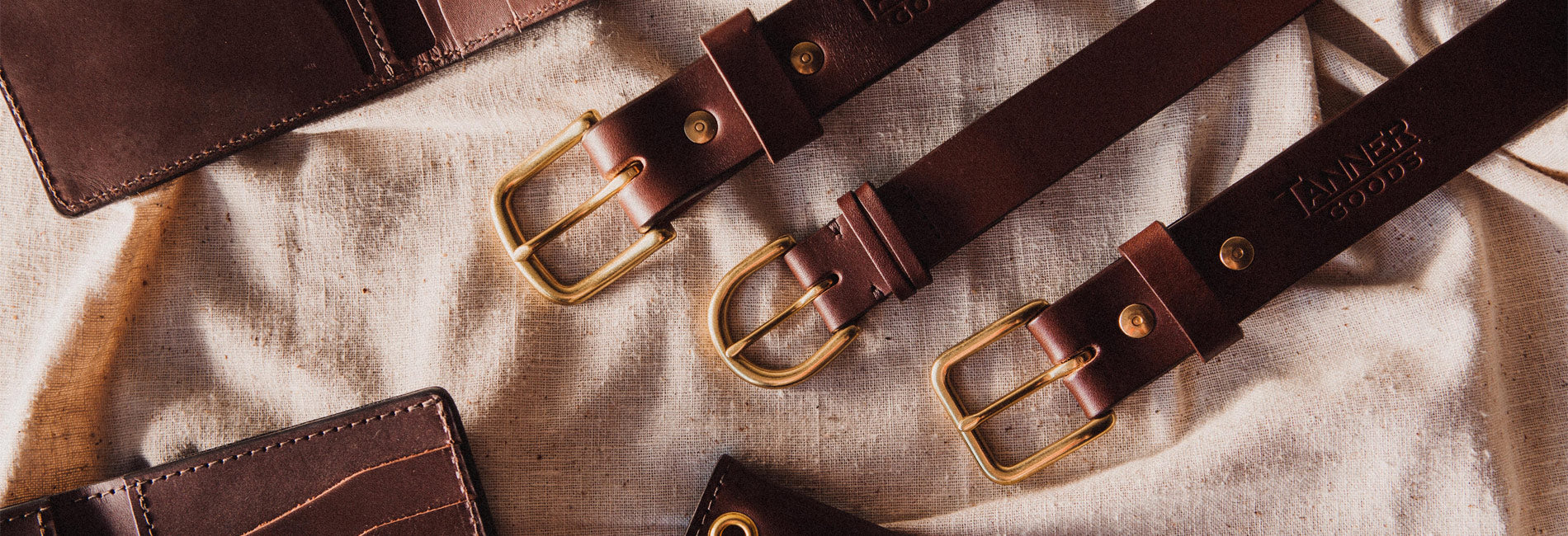 Rich cognac leather belts and wallets with brass hardware, artisan-crafted for timeless, rugged elegance.