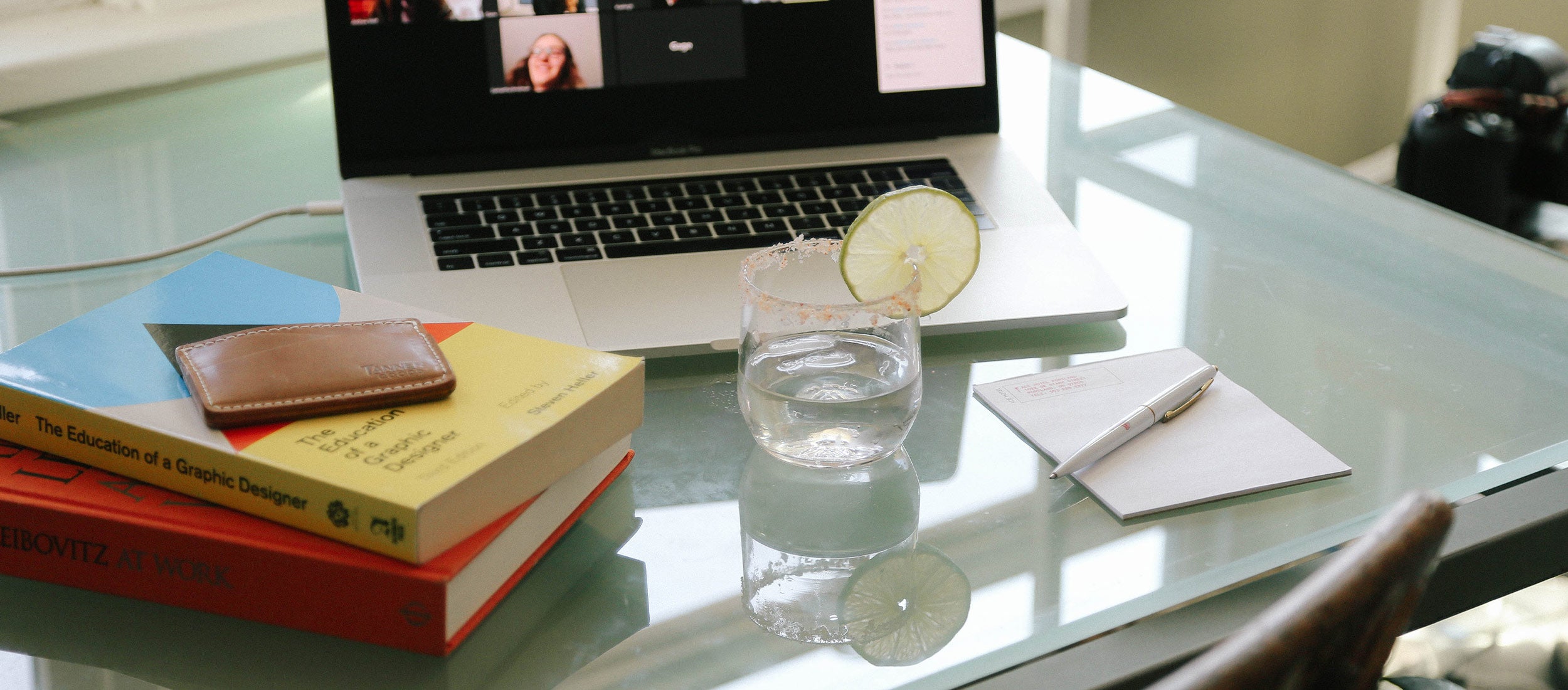 Grad Season: sleek leather wallet, designer books, margarita, laptop—celebrating achievement with modern, minimalist style.