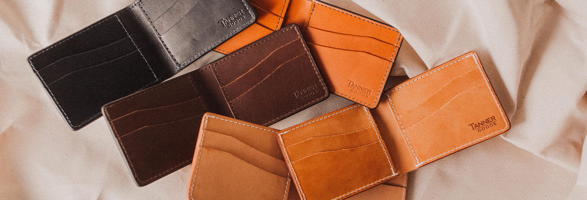 Rich leather utility bifolds in black, brown, and tan with contrast stitching, minimalist design, and premium craftsmanship.