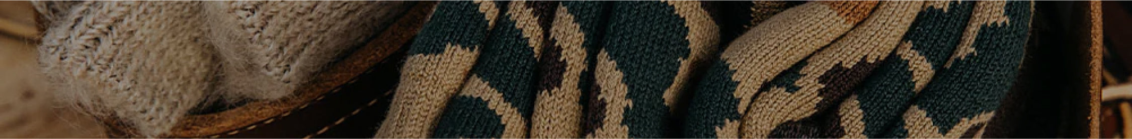 Cozy knitwear in earthy tones and geometric patterns, nestled in woven baskets, evoking warmth and artisan craftsmanship.