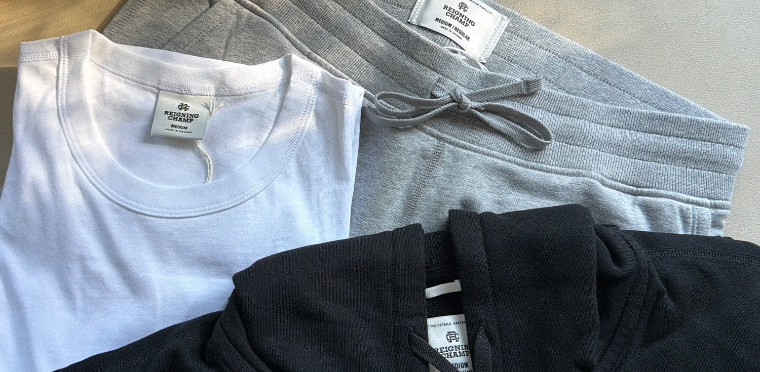 Minimalist loungewear in white, gray, and black with ribbed textures and branded tags, embodying timeless comfort and refined simplicity.