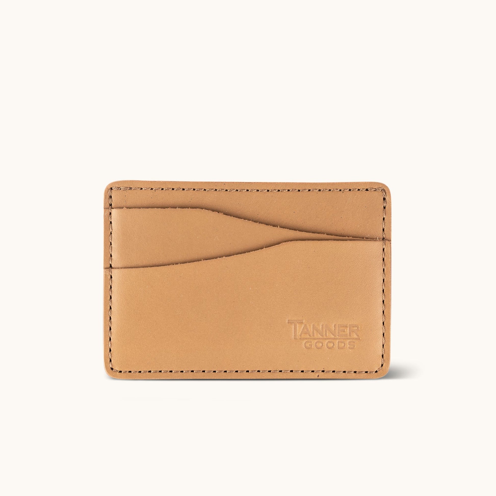 Light tan leather card wallet by Tanner Goods, featuring curved card slots and perimeter stitching.
