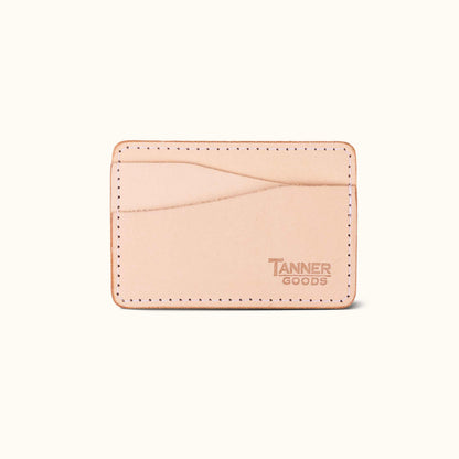 Natural leather money clip wallet by Tanner Goods with visible white stitching and debossed logo.