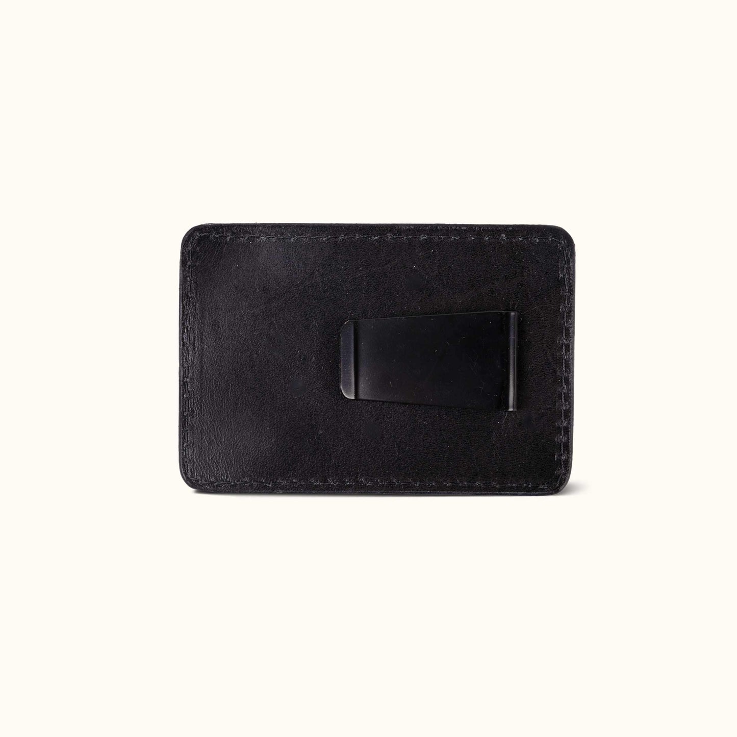 Black leather money clip with visible stitching and a black metal clip.