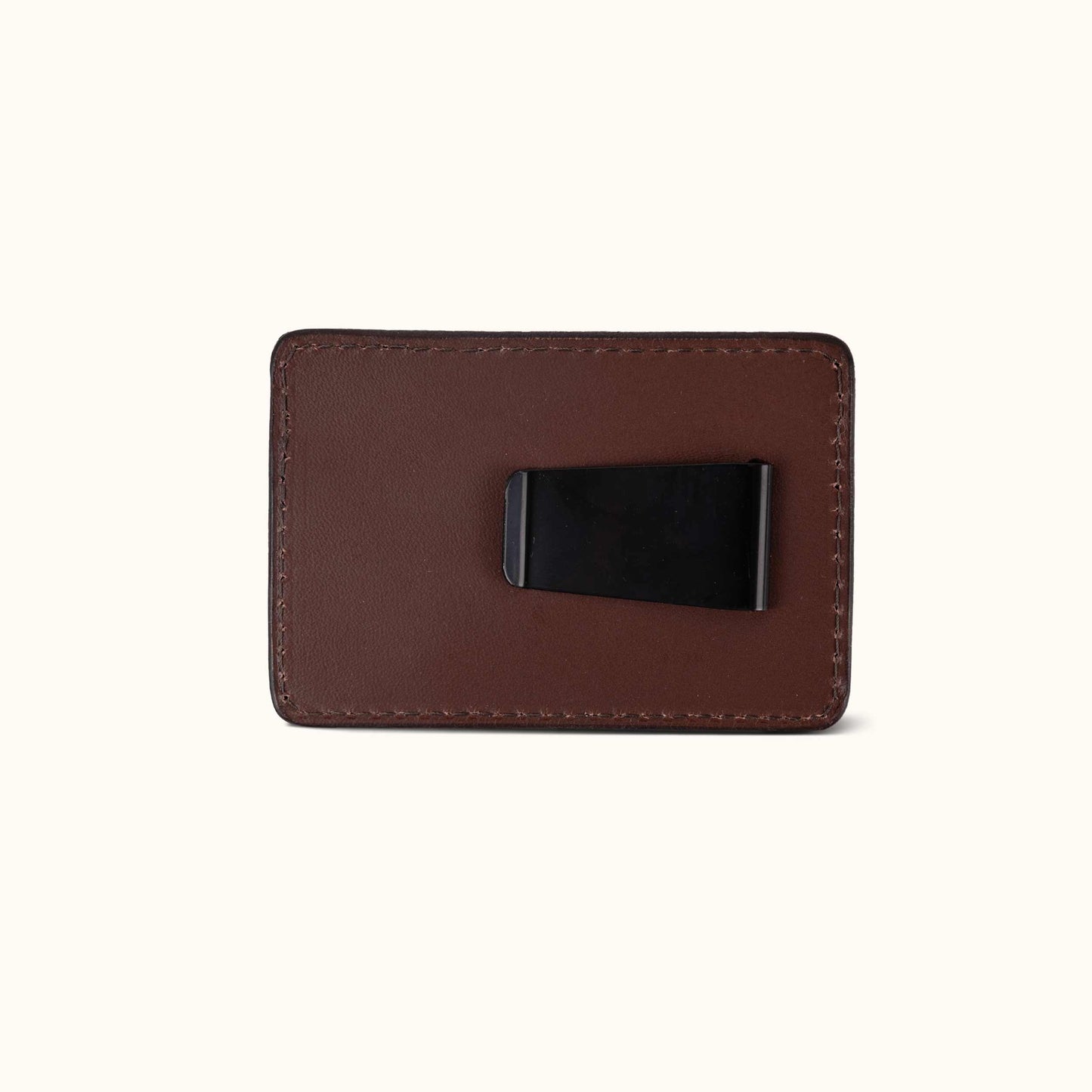 Cognac leather money clip with a black metal clip on the back and visible perimeter stitching.