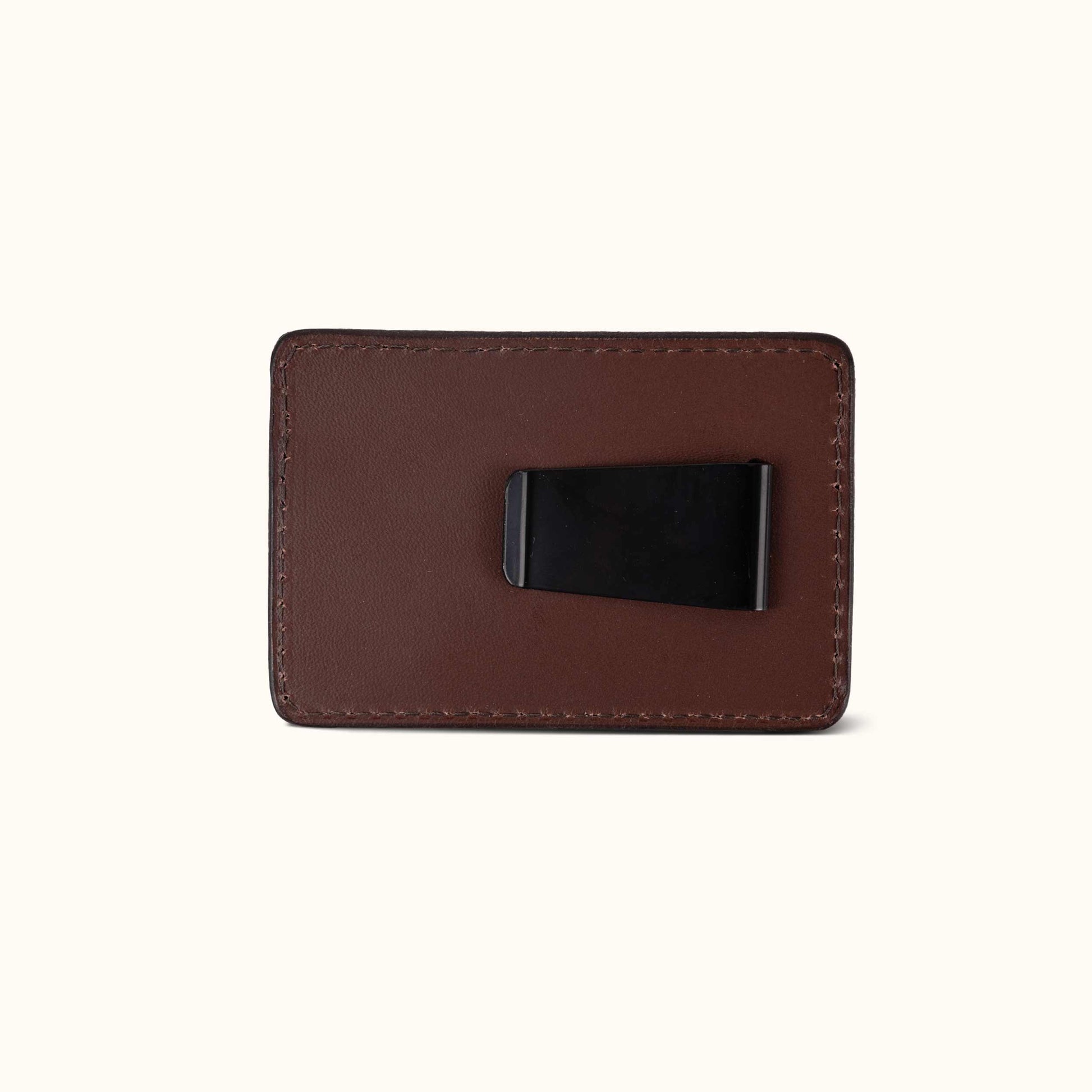 Cognac leather money clip with a black metal clip on the back and visible perimeter stitching.