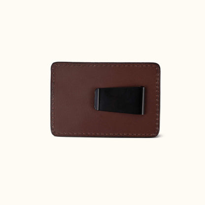 Cognac leather money clip with a black metal clip on the back and visible perimeter stitching.
