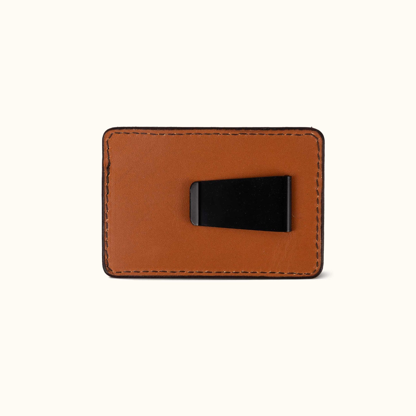 Saddle Tan leather money clip with a black metal clip on the reverse, showing detailed stitching.