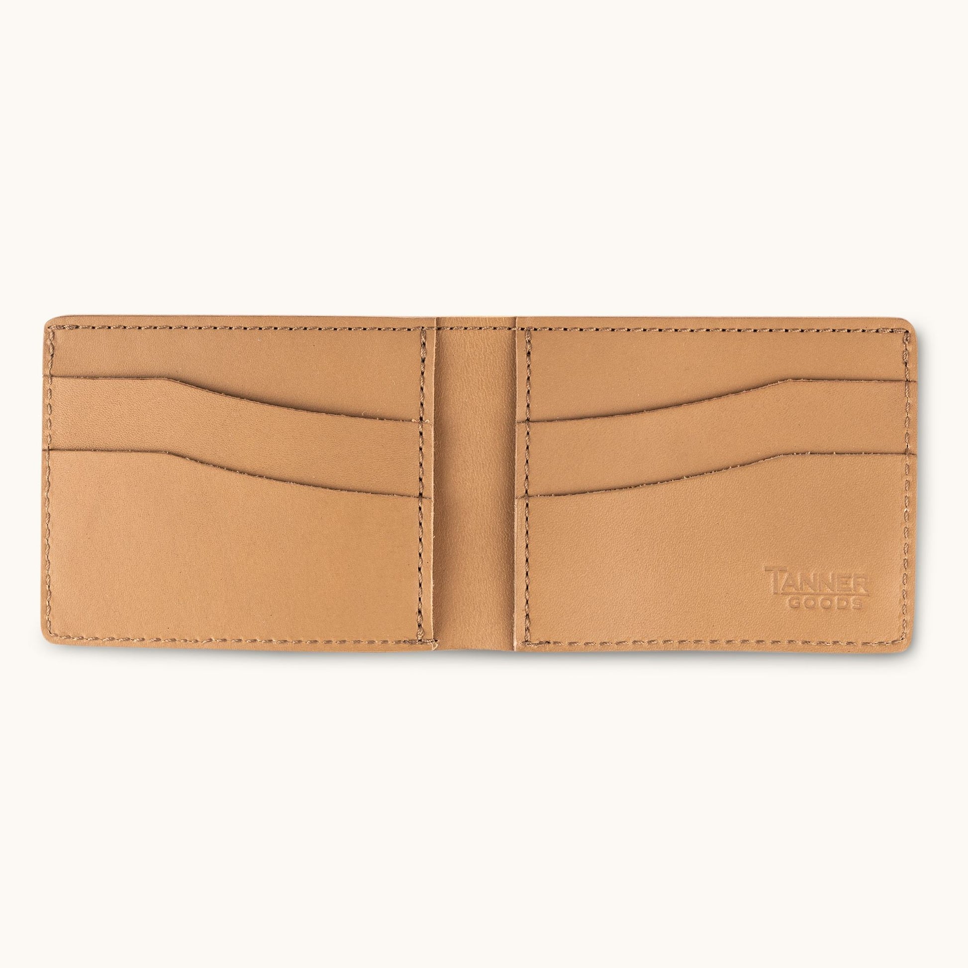 Light brown leather bifold wallet by Tanner Goods, open to show card slots and embossed logo.