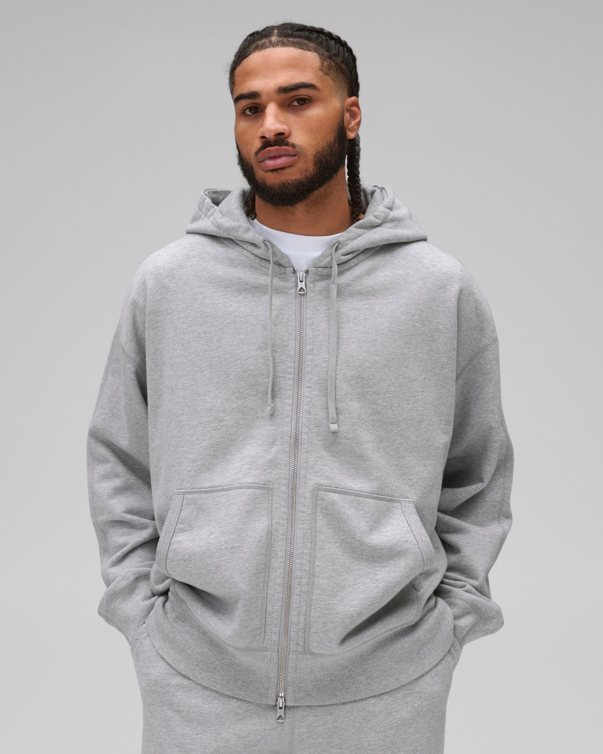 Grey Midweight Terry Relaxed Zip Hoodie with a full zipper, drawstrings, and front pockets, worn by a male model.