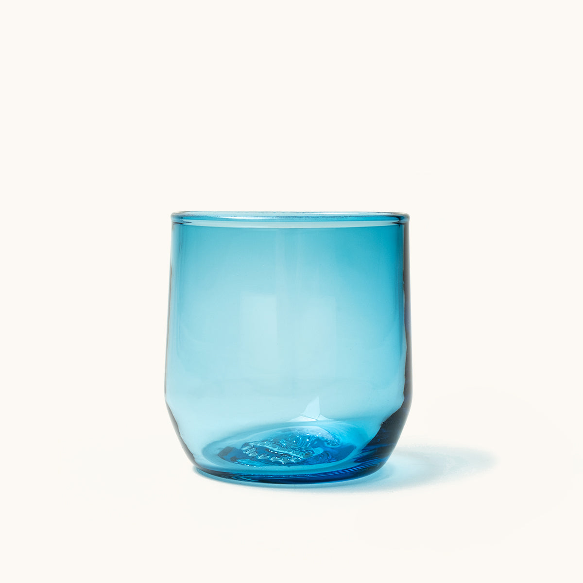 Blue cocktail glass with a smooth, translucent finish, showing light reflections against a white background.