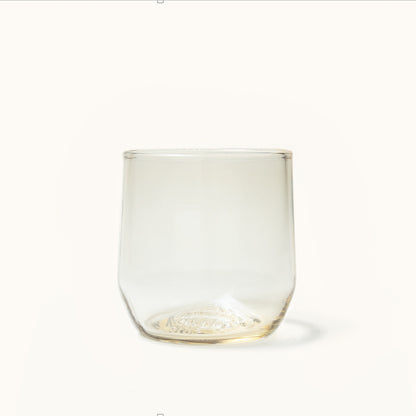 Clear stemless cocktail glass with a warm amber tint and an embossed, textured pattern on the base.