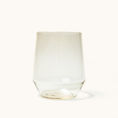 Stemless wine glass with a slight amber tint, featuring textured detail on the clear glass base.