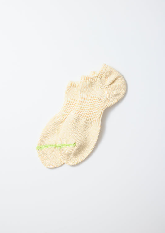 Cream chunky sneaker socks with a lime green stripe across the toes, laid flat.