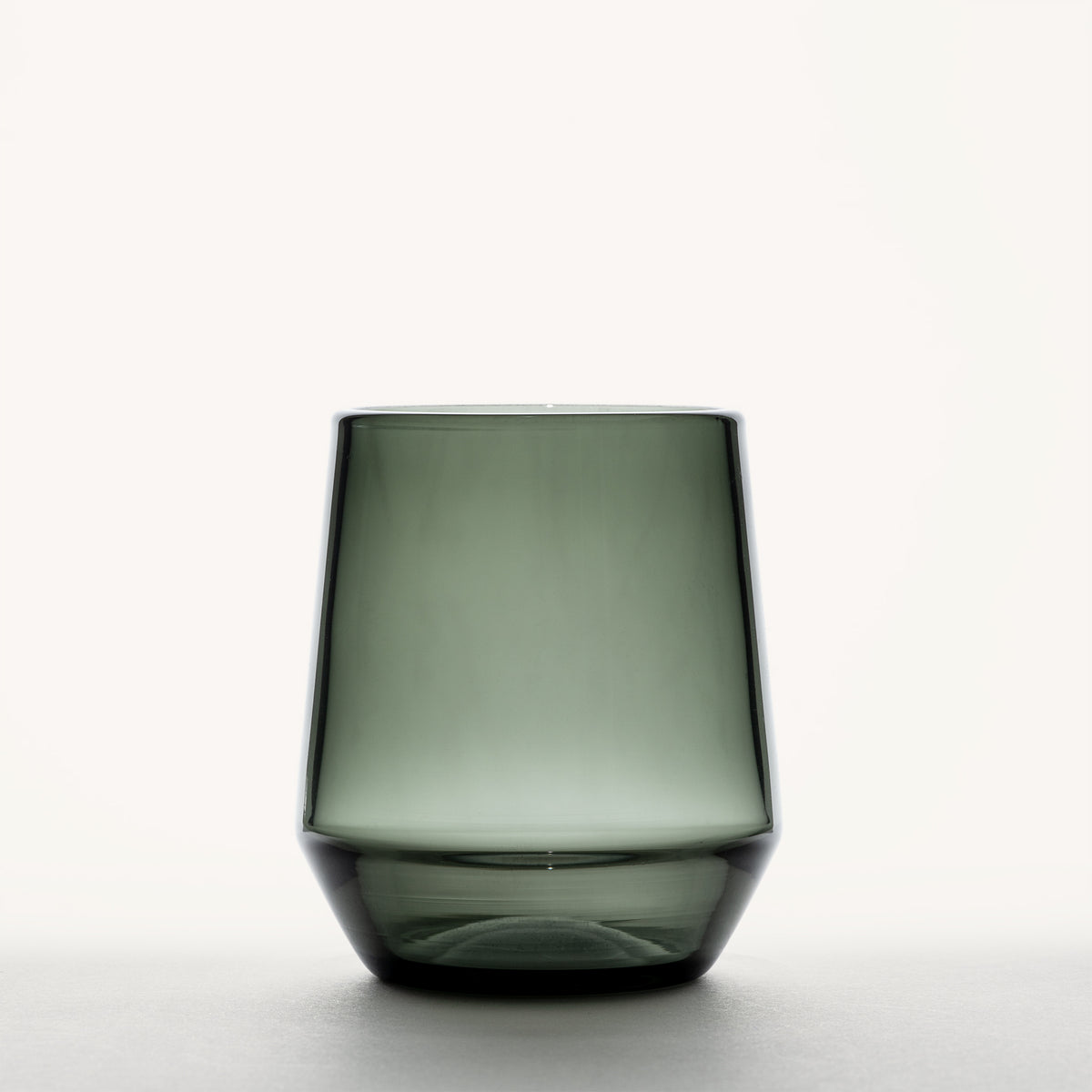 Smoke gray stemless wine glass with a thick rounded base, shown front-facing against a white background.