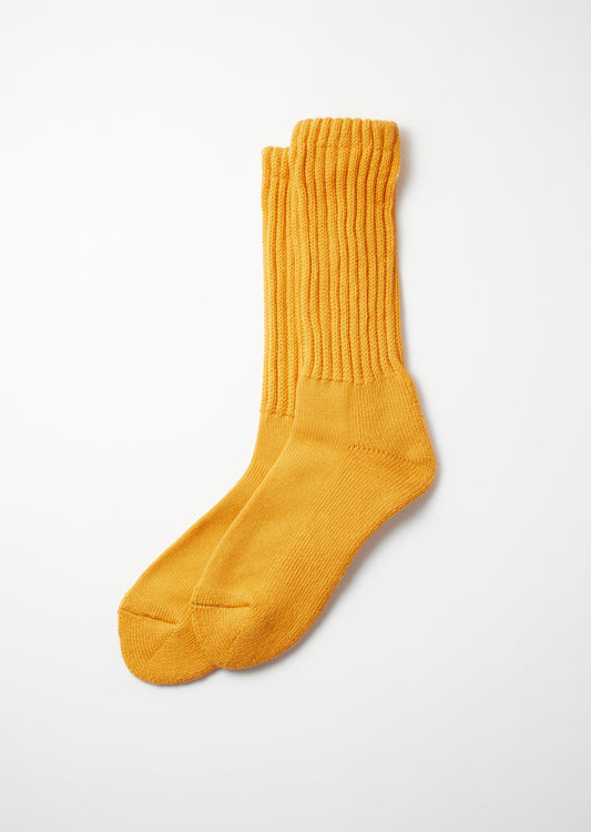 Mustard yellow loose pile crew socks with a ribbed knit texture, laid flat on a white background.