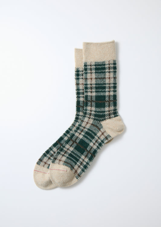Merino socks with a green, brown, and cream check pattern, featuring solid beige cuffs and toes, laid flat.