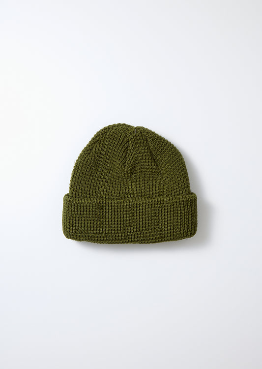 Dark olive green waffle knit watch cap with a ribbed cuff, flat lay.