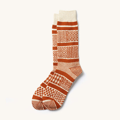 Ivory and rust multi jacquard crew socks featuring various geometric patterns, laid flat.