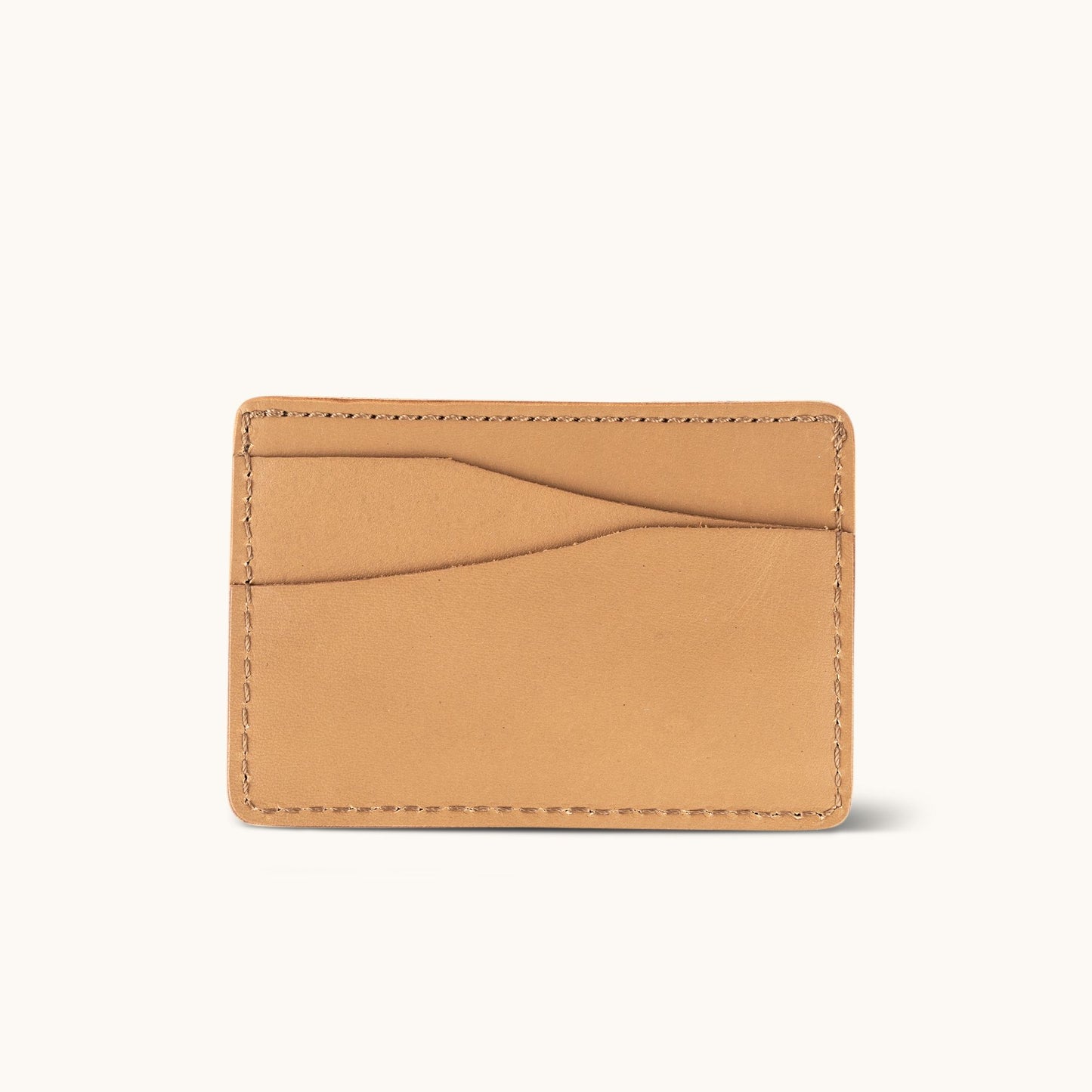 Light brown leather wallet with two curved card slots and visible perimeter stitching.