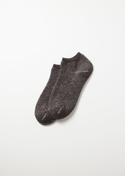 A pair of charcoal Washi Pile short socks, speckled with white flecks, angled on a white background.