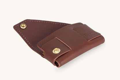 Cognac leather cardholder by Tanner Goods, opened, revealing interior, with two brass snaps and an embossed logo.