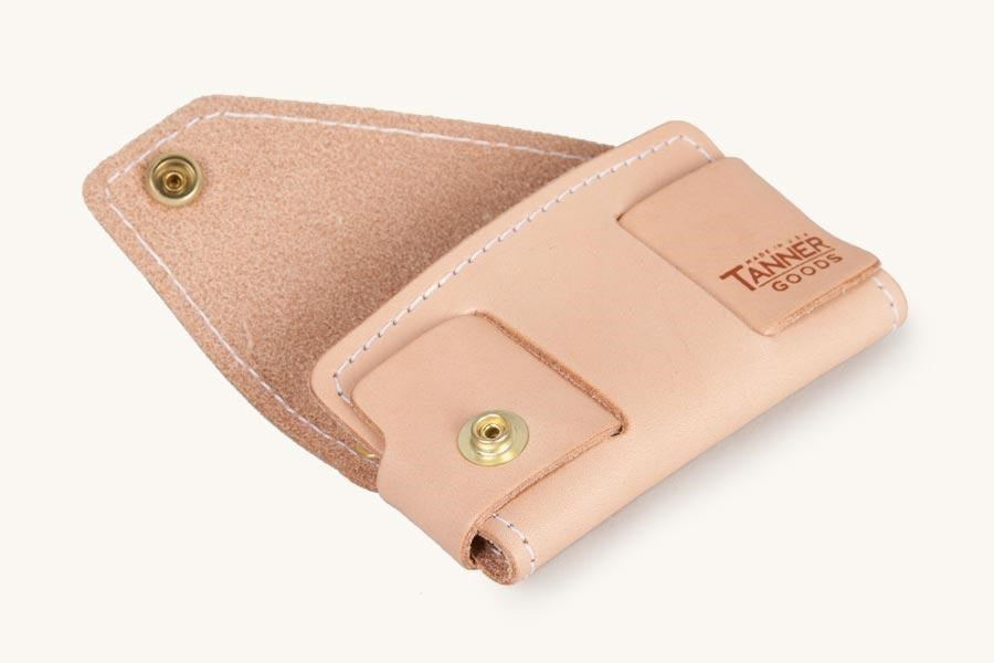 Natural leather cardholder by Tanner Goods, partially open, with white stitching and brass snap.