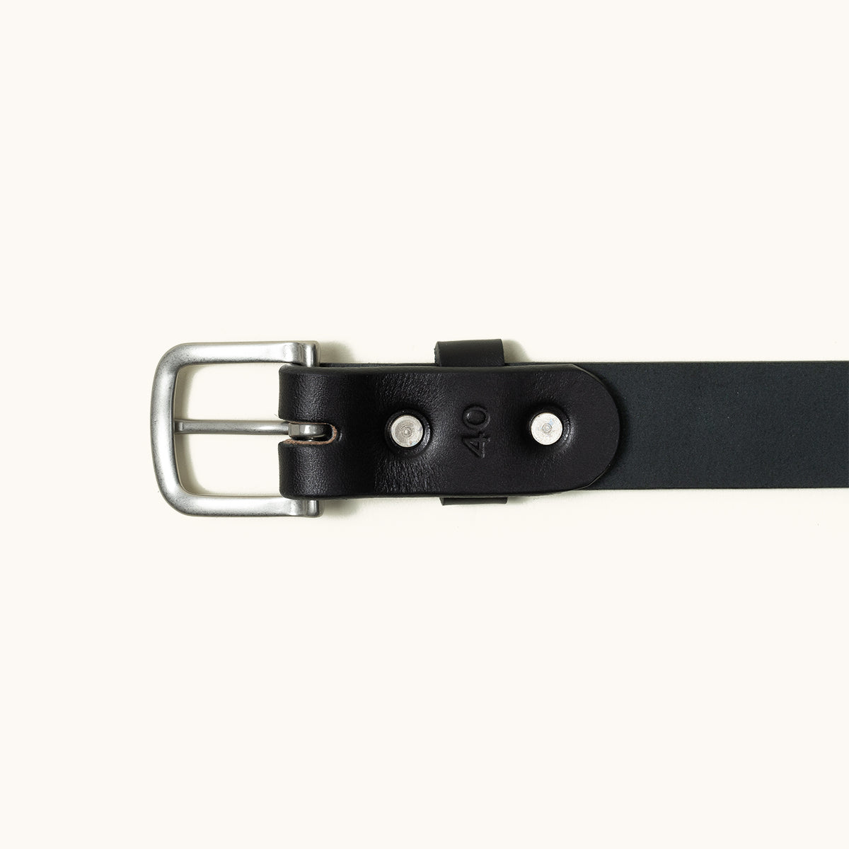 Classic black leather belt with a silver buckle, stamped '40', and two visible rivets, flat lay.