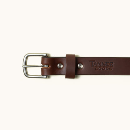 Brown leather classic belt by Tanner Goods with a silver buckle and embossed logo.
