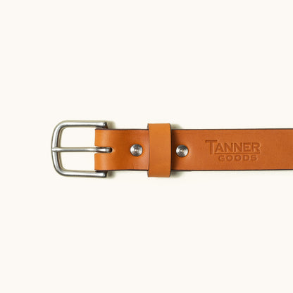 Tan leather belt with a silver buckle, featuring two rivets and embossed lettering.