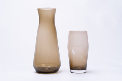 Smoky brown glass pint with a white base, displayed next to a taller matching carafe.