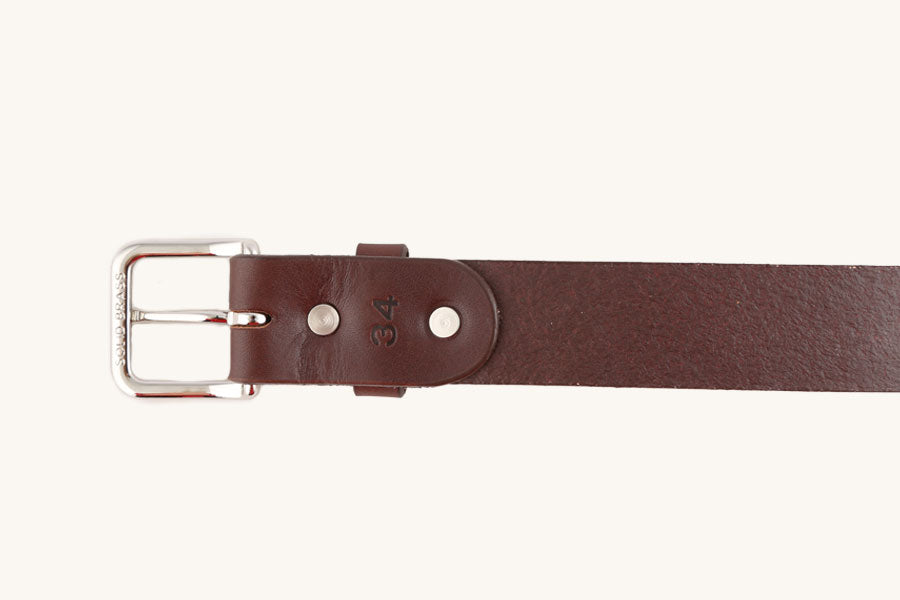 Cognac leather belt with a silver-toned "SOLID BRASS" buckle and "34" stamped on the strap.