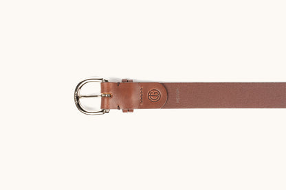 A cognac brown leather belt with a polished silver-toned buckle engraved "BRASS" and an embossed circular logo.