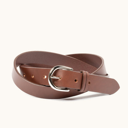 Cognac leather belt with a silver buckle, coiled against a white background.