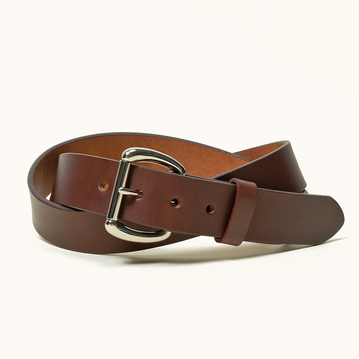 A coiled cognac belt with a stainless roller bar belt buckle.
