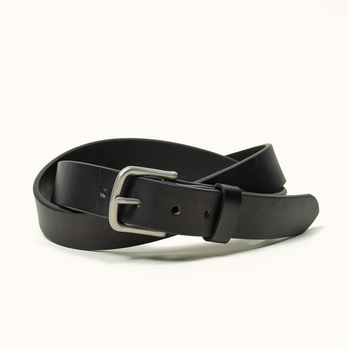 Black classic leather belt with a silver-toned metal buckle, coiled on a white background.
