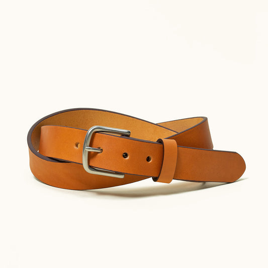 Saddle tan leather classic belt with a silver-tone buckle, coiled.