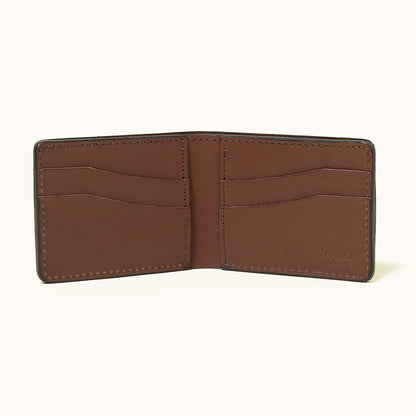Cognac leather bifold wallet by Tanner Goods, open to show six card slots and an embossed logo.