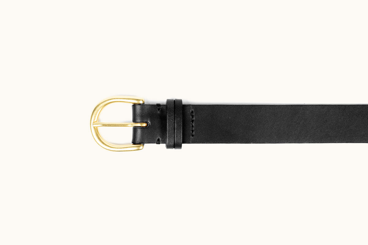 Black leather belt with a rounded gold-toned buckle and a single keeper loop, flat lay.