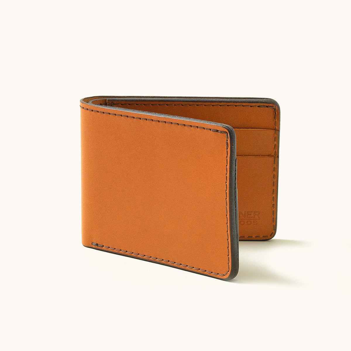 Saddle Tan leather Utility Bifold wallet, partially open to show card slots and dark finished edges.