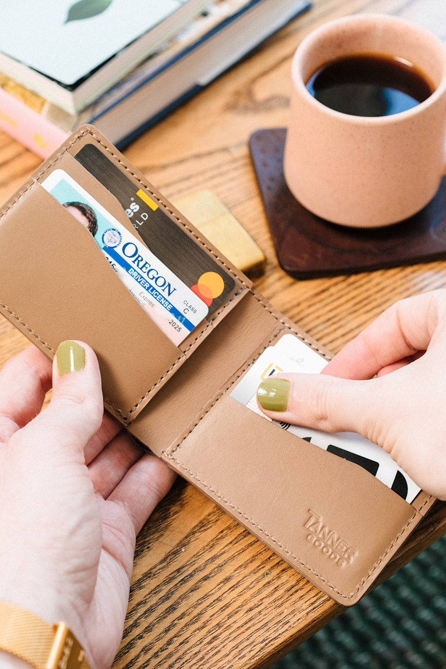Hands opening a Stone Grey Bifold pulling out a credit card.