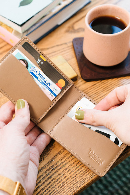Hands opening a Stone Grey Bifold pulling out a credit card.