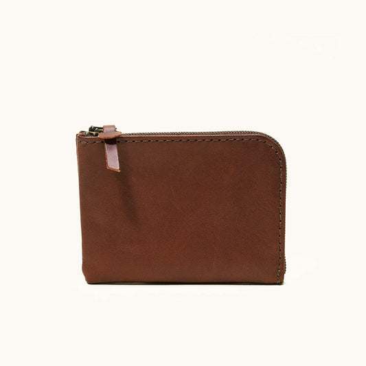 Cognac leather zip wallet with exposed stitching and a leather tab zipper pull, shown from the front.