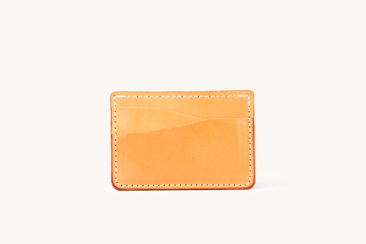 Golden leather wallet with white stitching and two front card slots, presented on a white background.