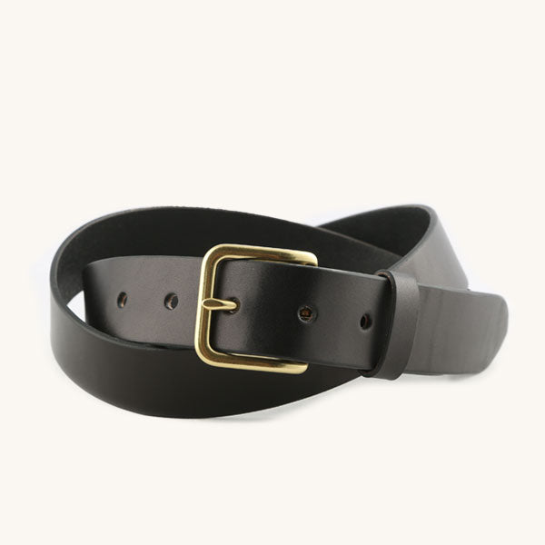 Black leather belt with a brass-toned rectangular buckle and visible adjustment holes, coiled on a white background.